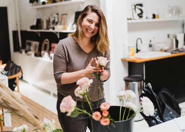 a woman is arranging flowers in a vase