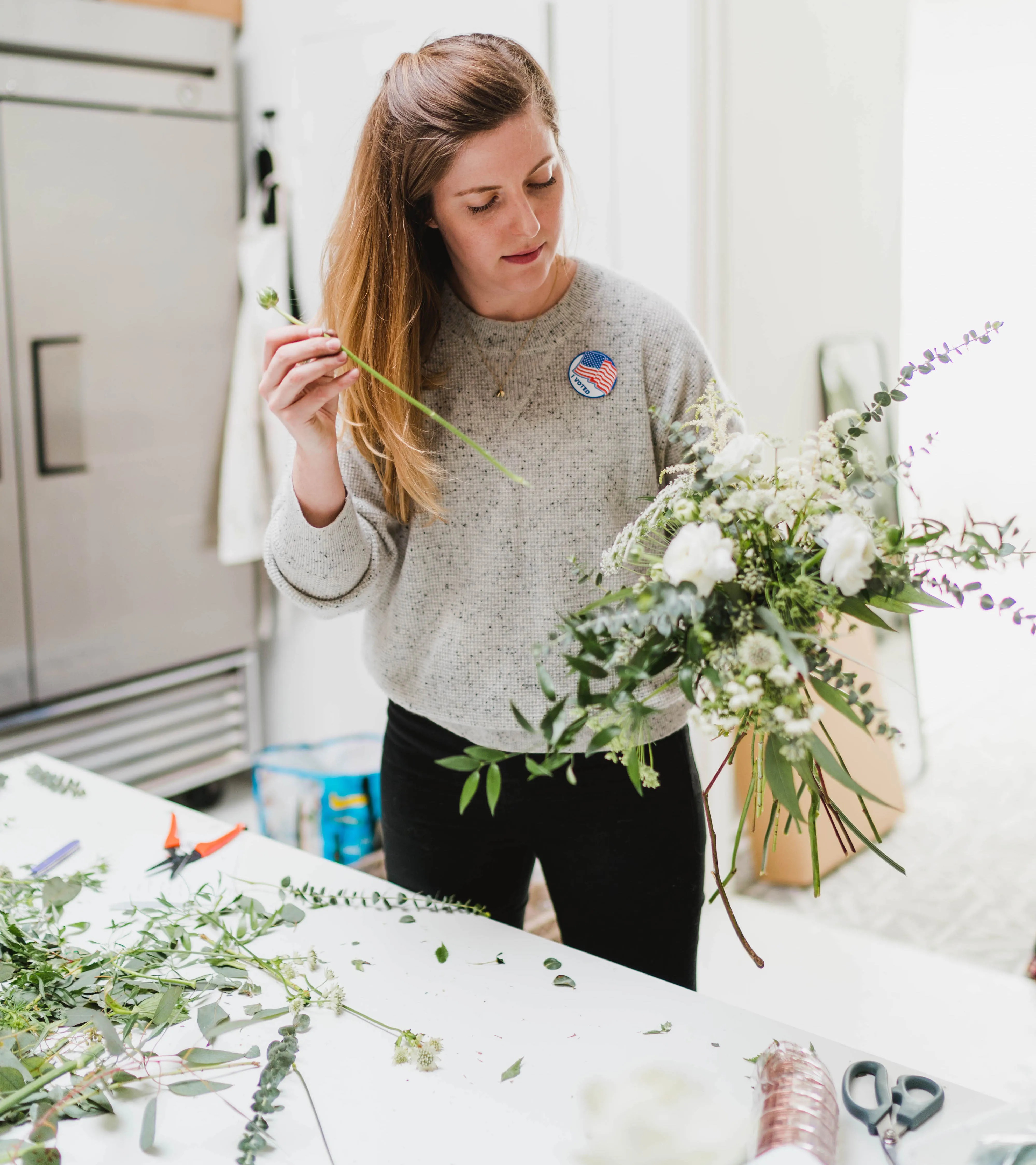 a woman holding a bouquet of flowers in a kitchen