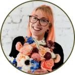 a woman with glasses holding a bouquet of flowers