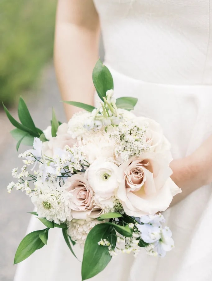 Bride holding a small, classic white spring wedding bouquet