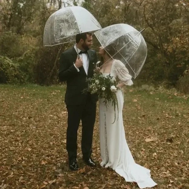 Greenery wedding bouquet held by the couple amidst a verdant setting